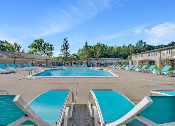 A large outdoor swimming pool surrounded by sun loungers.