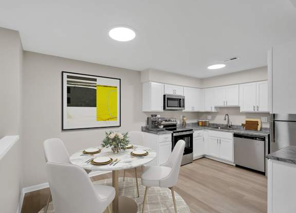A modern kitchen with a dining table set for two.
