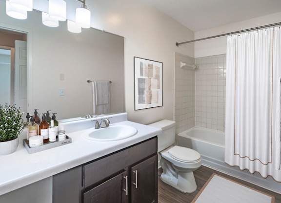 A bathroom with a white sink, toilet, and bathtub.