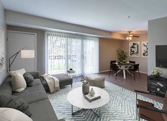 A living room with a grey couch, a white coffee table, and a television.