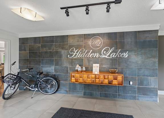 A bicycle is parked in front of a wall with a sign that reads