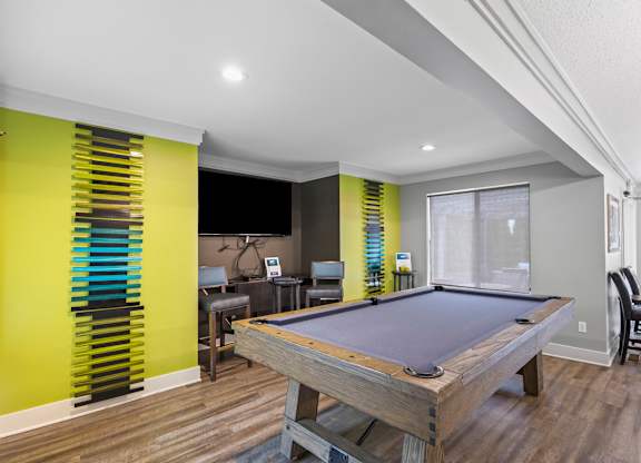 A pool table in a room with a yellow wall.