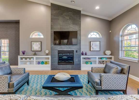 A clubhouse with a fireplace and a blue rug.