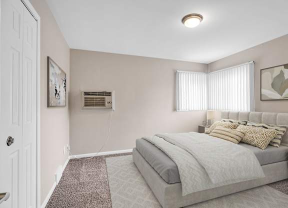 A bedroom with a bed, a window with blinds, and a painting on the wall.