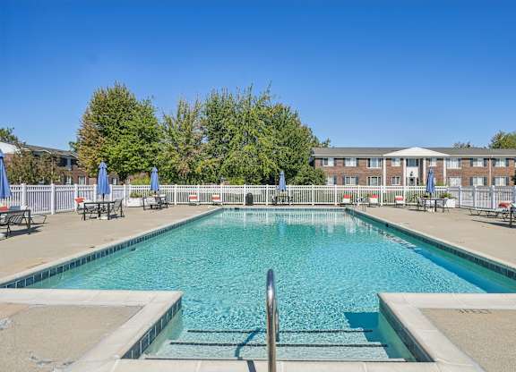 A large swimming pool with a metal ladder in the middle.