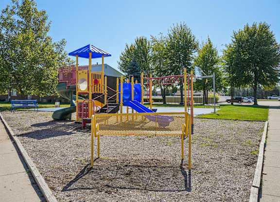 A playground with a blue and yellow swing set.