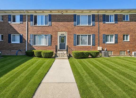 A brick building with a green lawn in front.