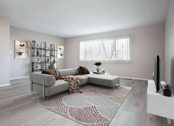 Living room with a grey sofa and a patterned rug at Versailles, 25026 E Rue Versailles, Oak Park