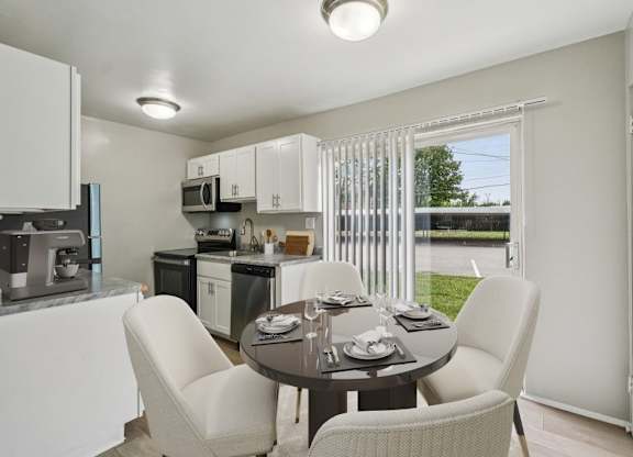 Modern kitchen with a dining table set for four at Versailles, 25026 E Rue Versailles, Oak Park, MI 