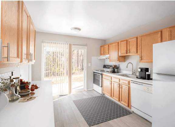 Kitchen with white appliances and wooden cabinets at Versailles, 25026 E Rue Versailles, 48237