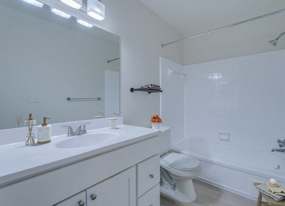 A white bathroom with a sink, toilet, and bathtub.
