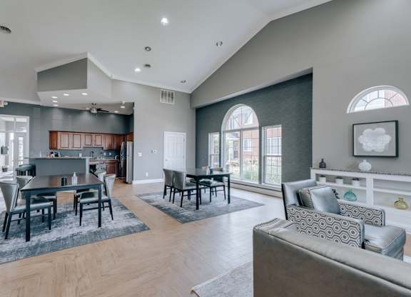 A modern living room with a dining area and a kitchen in the background.