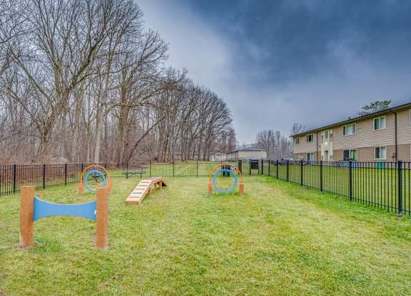A playground with a blue swing set and a green slide.
