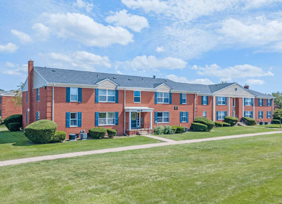 A red brick building with a green lawn in front.