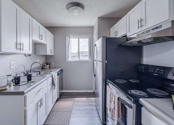 A kitchen with white cabinets and a black stove top oven.