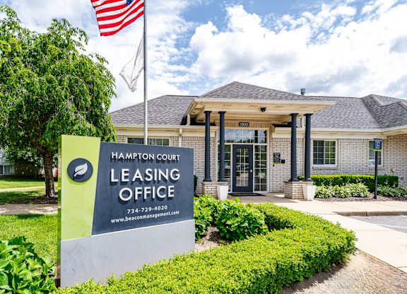 Hampton Court Leasing Office with a sign in front.