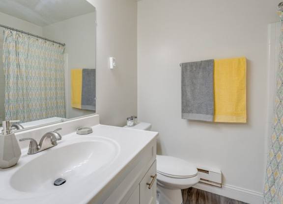 A bathroom with a white sink and a toilet.