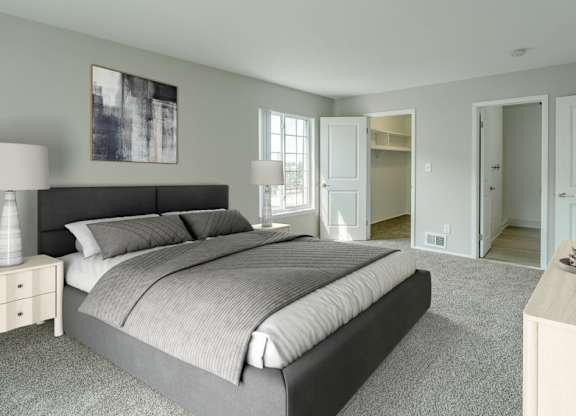 A bedroom with a large bed and a nightstand with a lamp.