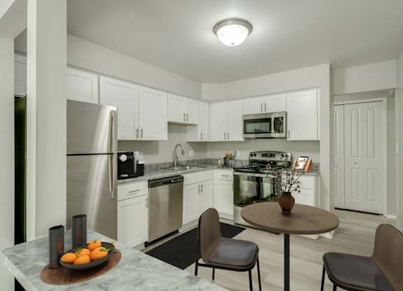 A kitchen with a table and chairs in the middle of it.
