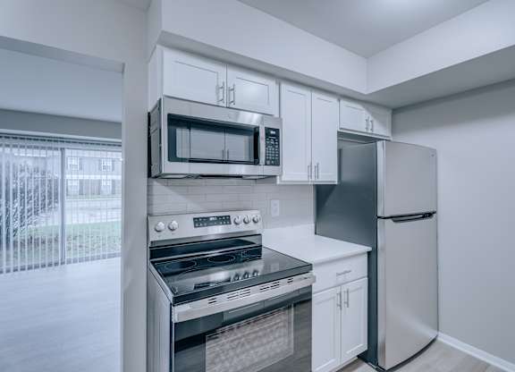 A kitchen with white cabinets and appliances.