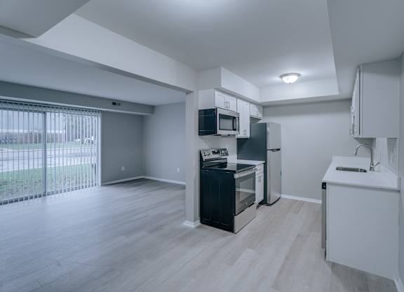 A kitchen with a black fridge and white cabinets.