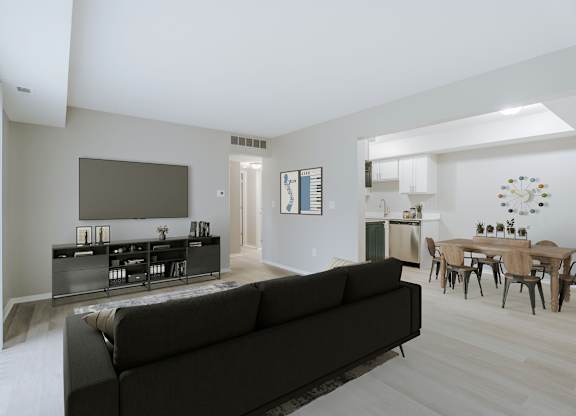A living room with a black couch and a television.