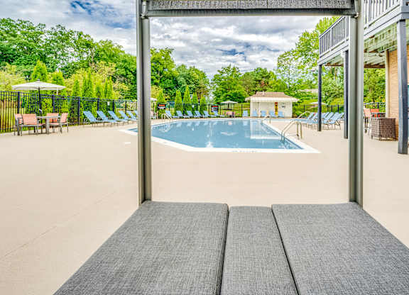 A large outdoor swimming pool with a view of the trees.