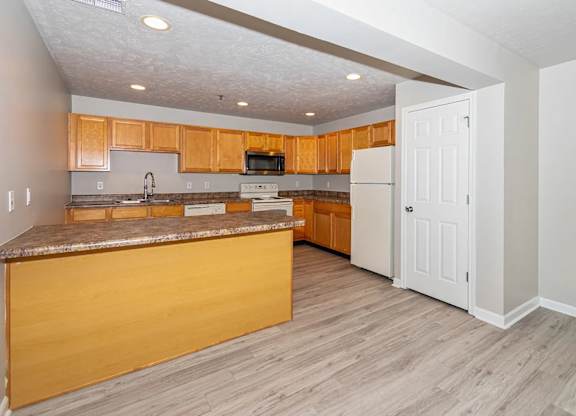 A kitchen with wooden cabinets and a white refrigerator.