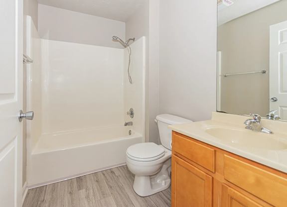 A white bathroom with a toilet, sink, and bathtub.