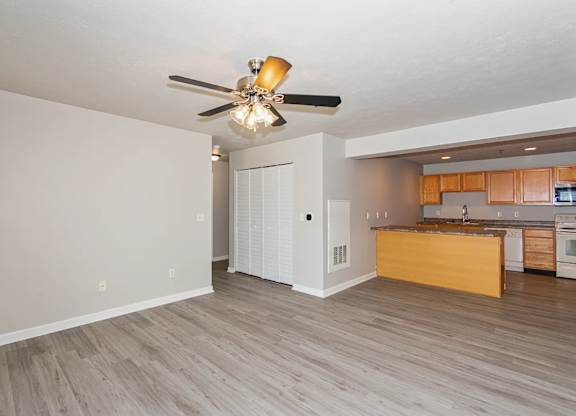 A kitchen with a ceiling fan and light fixture.