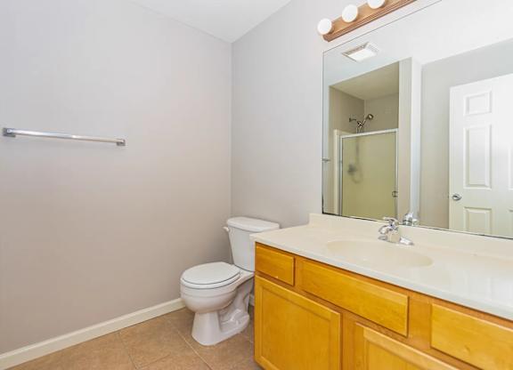 A white toilet sits in a bathroom next to a sink.