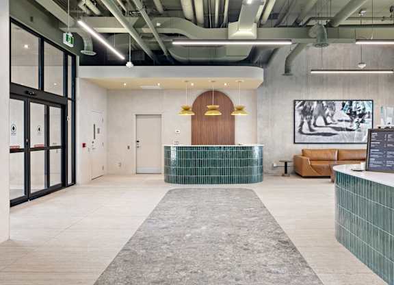 A reception area with a wooden door and a green tile counter.