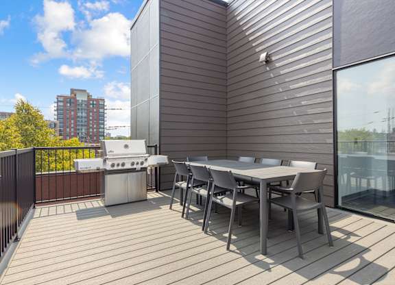 A patio with a table and chairs overlooking a cityscape.