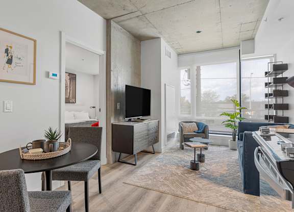 A modern living room with a flat screen TV and a dining table.