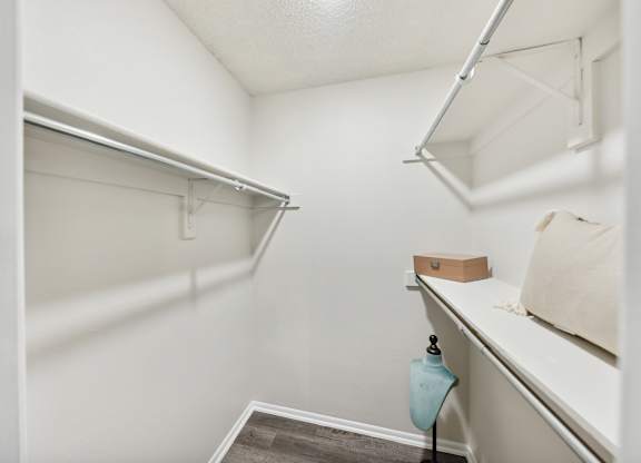 A small, white closet with a shelf and a hanging rod.