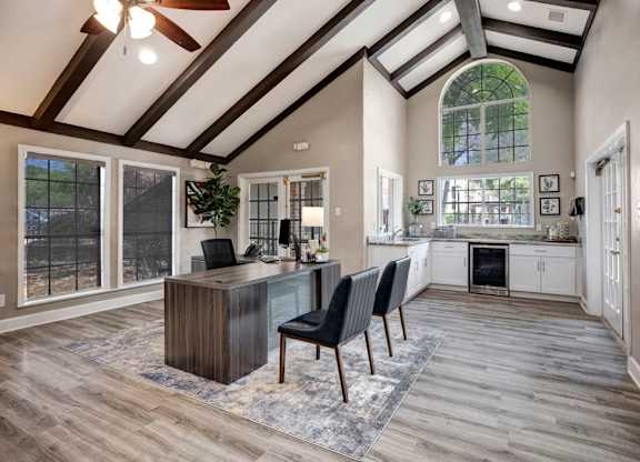 A modern home office with a wooden desk and chairs.