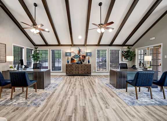 A spacious office with wood floors and ceiling fans.