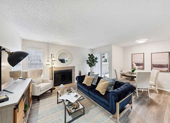 A living room with a blue couch and a fireplace.