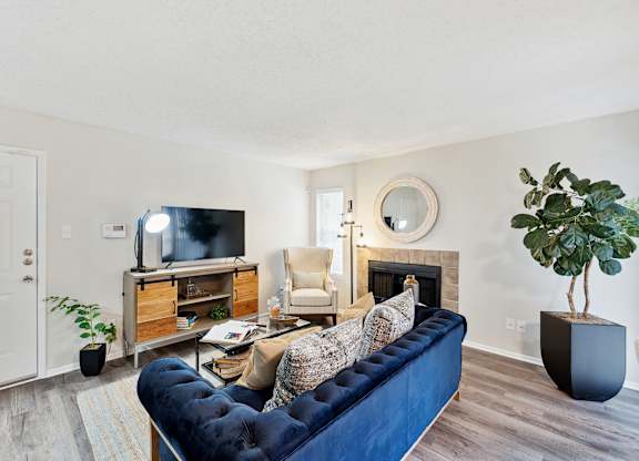 A living room with a blue couch and a television.