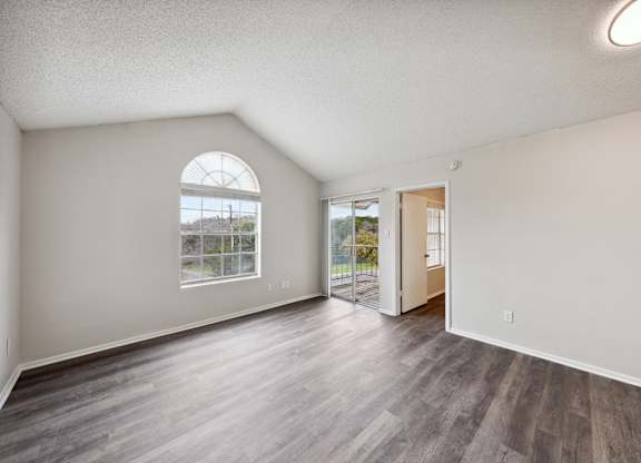 A room with a large window and a wooden floor.