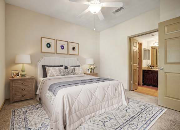 A bedroom with a large bed and a ceiling fan.