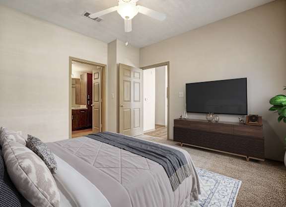 A bedroom with a bed, a television, and a plant.