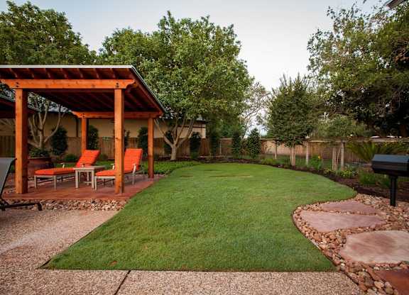 A backyard with a gazebo and a mailbox.