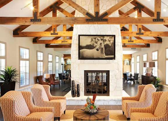 A living room with a fireplace and a painting of a dog.