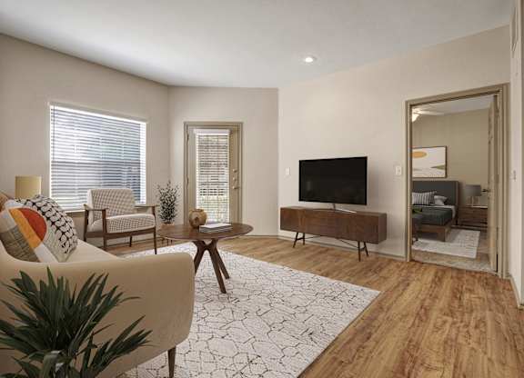 A living room with a sofa, a coffee table, a TV, and a plant.
