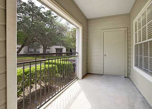 A balcony with a black railing and a white door.