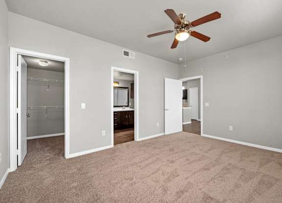 A room with a ceiling fan and carpeted floor.