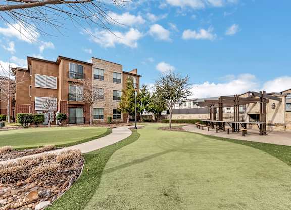 A large grassy area in front of apartment buildings.