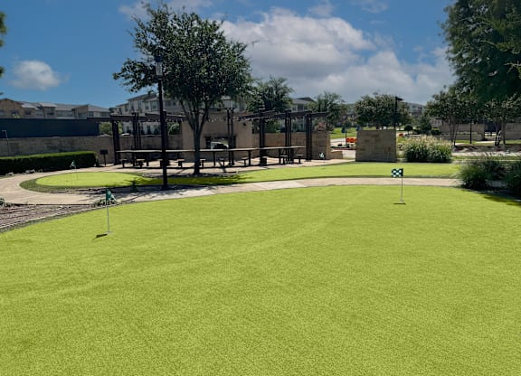 A green lawn with a sign in the distance.
