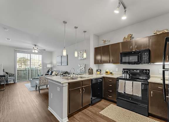 A kitchen with a black stove top oven and a white counter top.